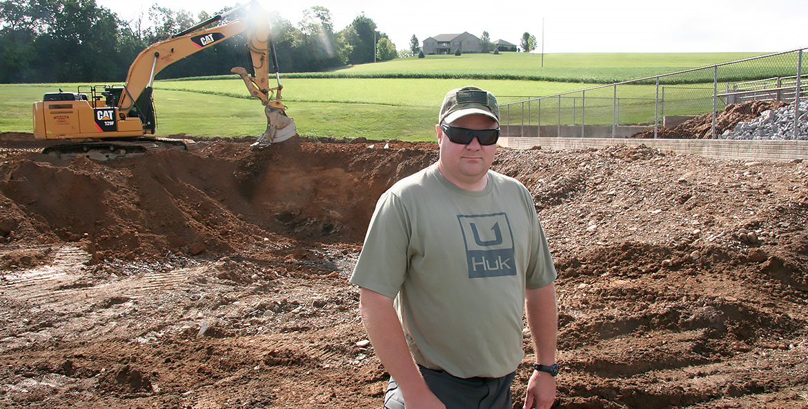 Greg Strayer stands in front of a construction area.