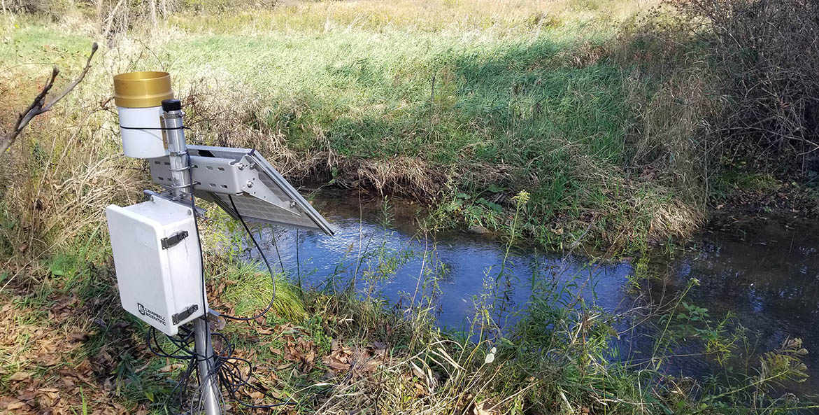 Scientific monitoring equipment next to a stream.
