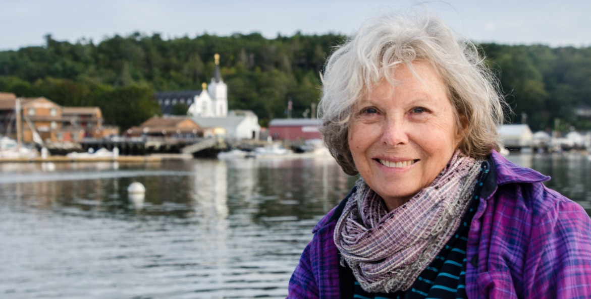 Woman with water and a town in the background.