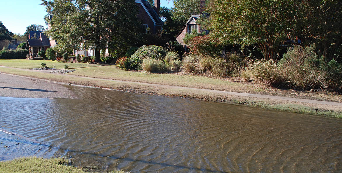 Flood waters flowing over a street.