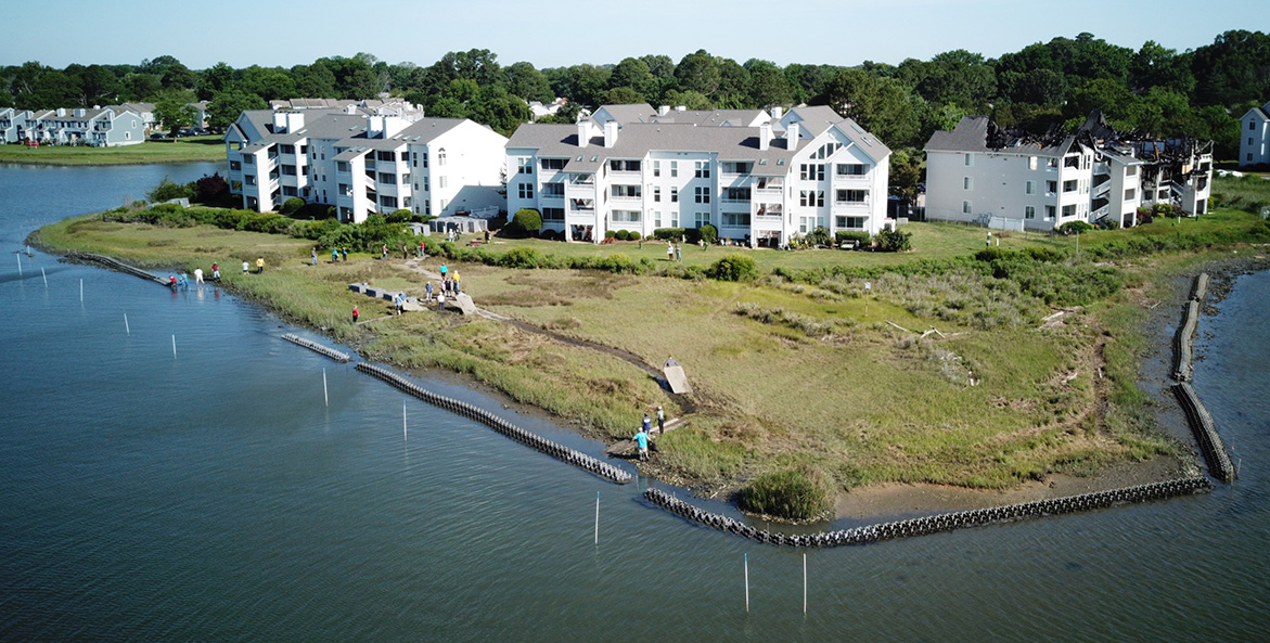 The waterway surrounding a condo development is bordered by bags of oyster shell.