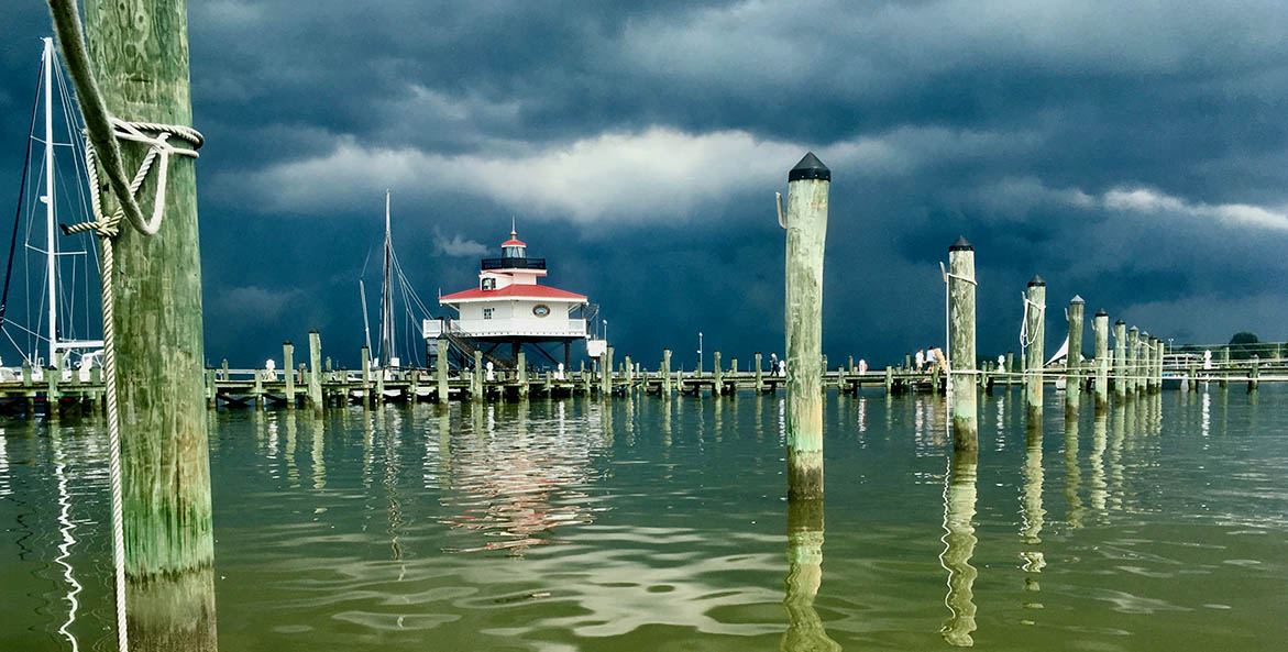 Storm clouds gather over a lighthouse in the Bay.