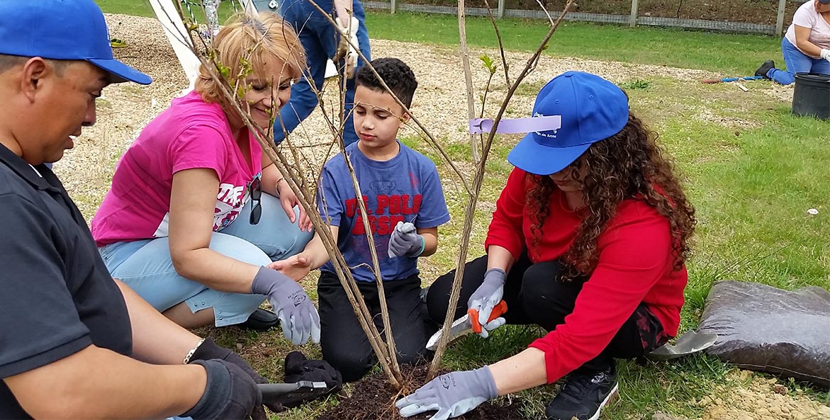 Arlene Guzman and son Ronald plant a tree 1171x593