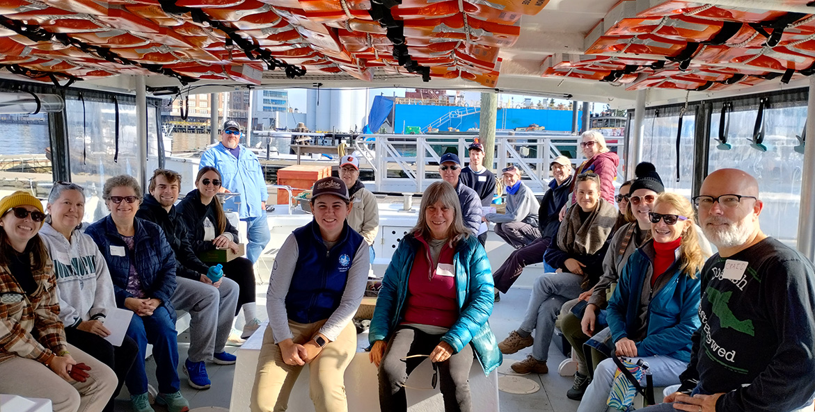 A group of people smile while on a boat