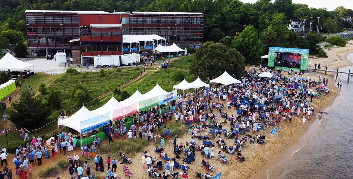 An aerial view of white tents and people on a beach