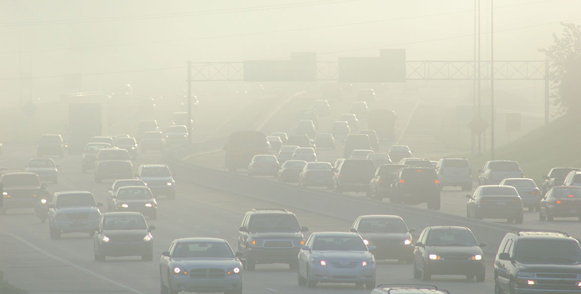 Cars driving through smog caused by air pollution