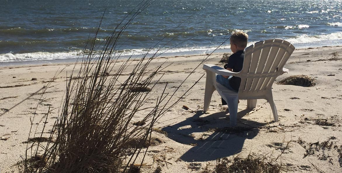 Child sitting on beach TravisHellebrandt 1171x593