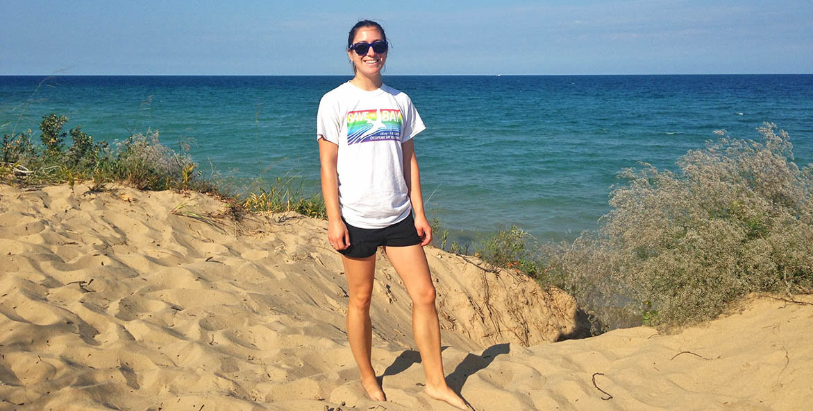 Woman standing on the shores of Lake Michigan wearing a CBF T-shirt.