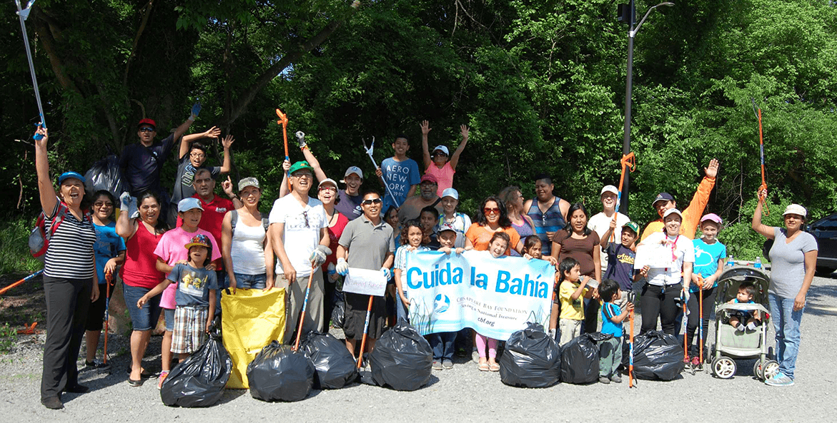 A group poses with a banner after picking up litter