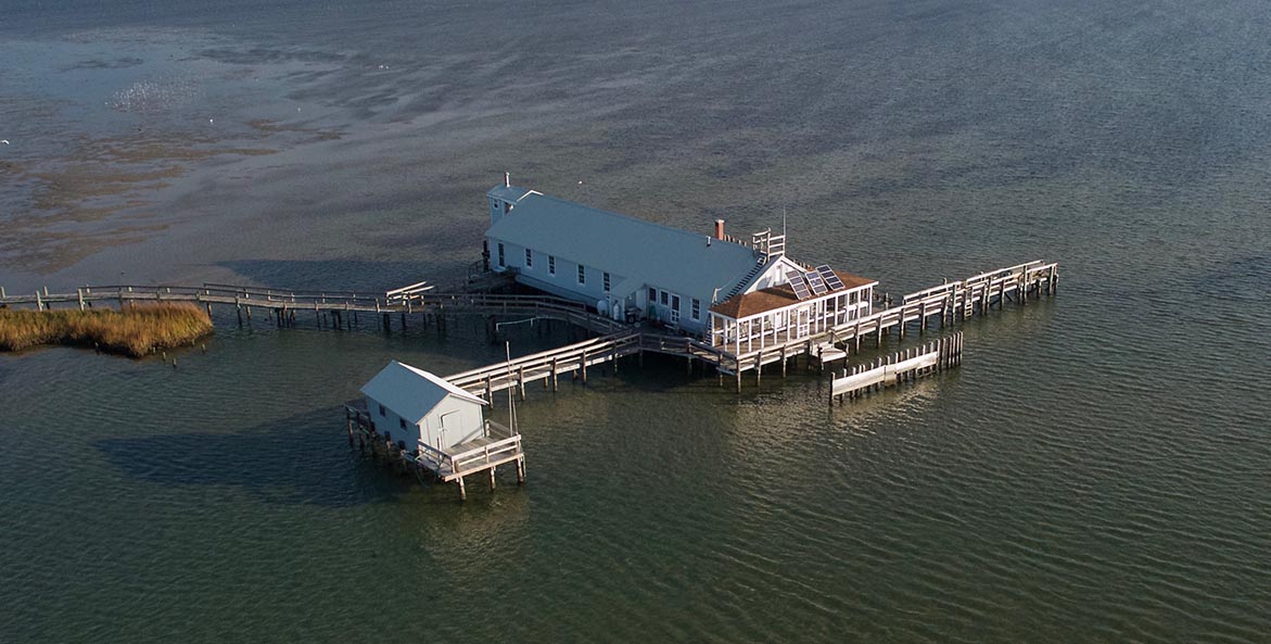 A building on stilts is completely surrounded by water.