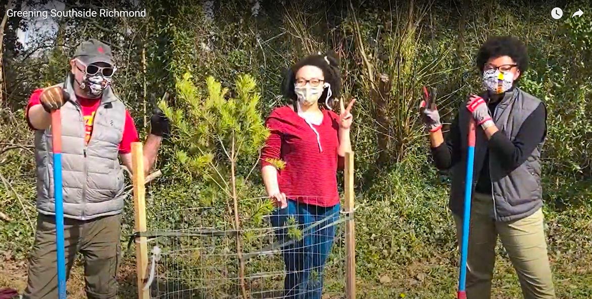 Three tree-planting volunteers pose with their tools