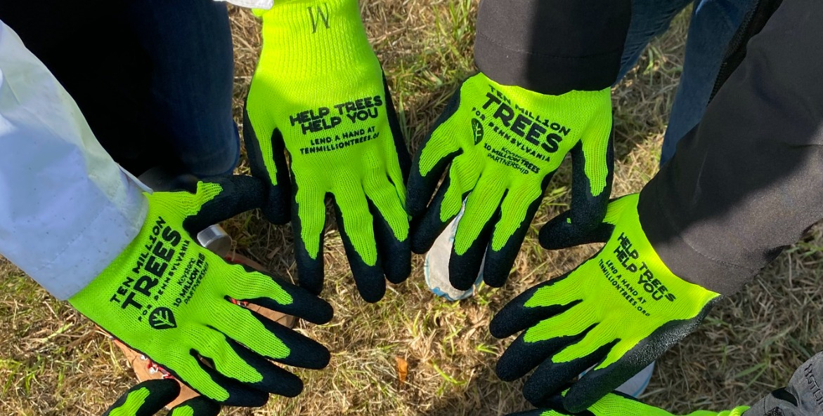 Several lime green and black work gloves displayed in a half-circle.