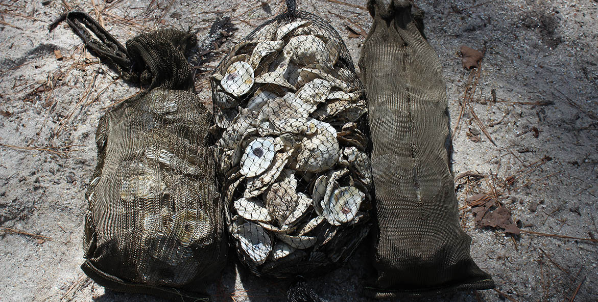 Two basalt fiber oyster shell bags on either side of a traditional mesh oyster shell bag. 