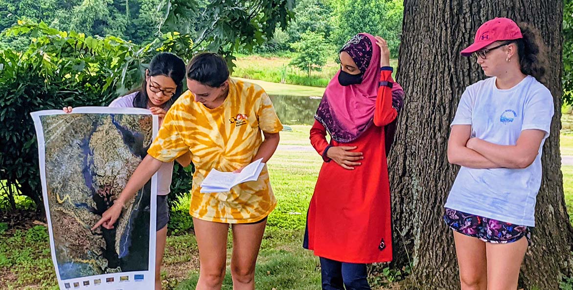 teachers and students look at watershed map 1171x593