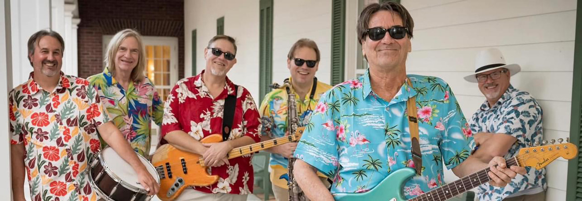 Six male band members in Hawaiian shirts with their instruments.