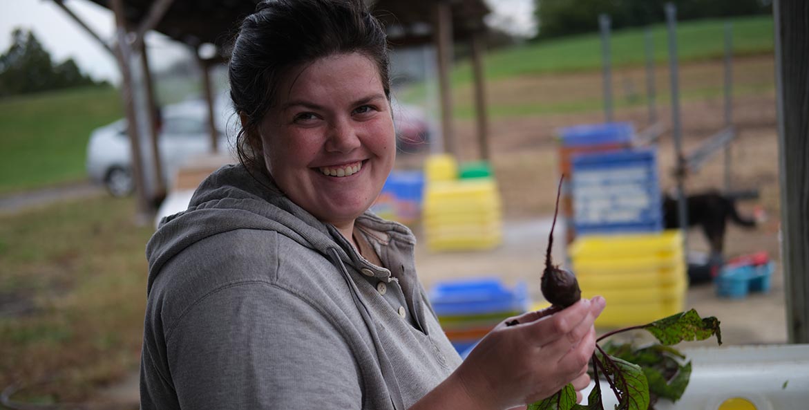 Womand holding a fresh, recently harvested beet.