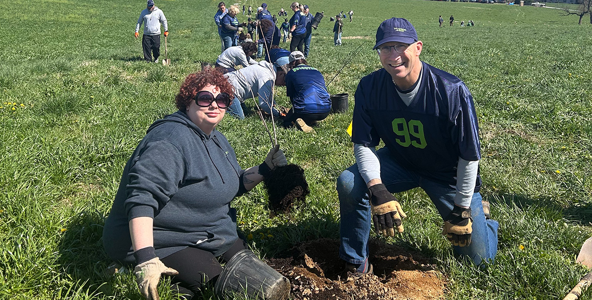Two people plant a tree.