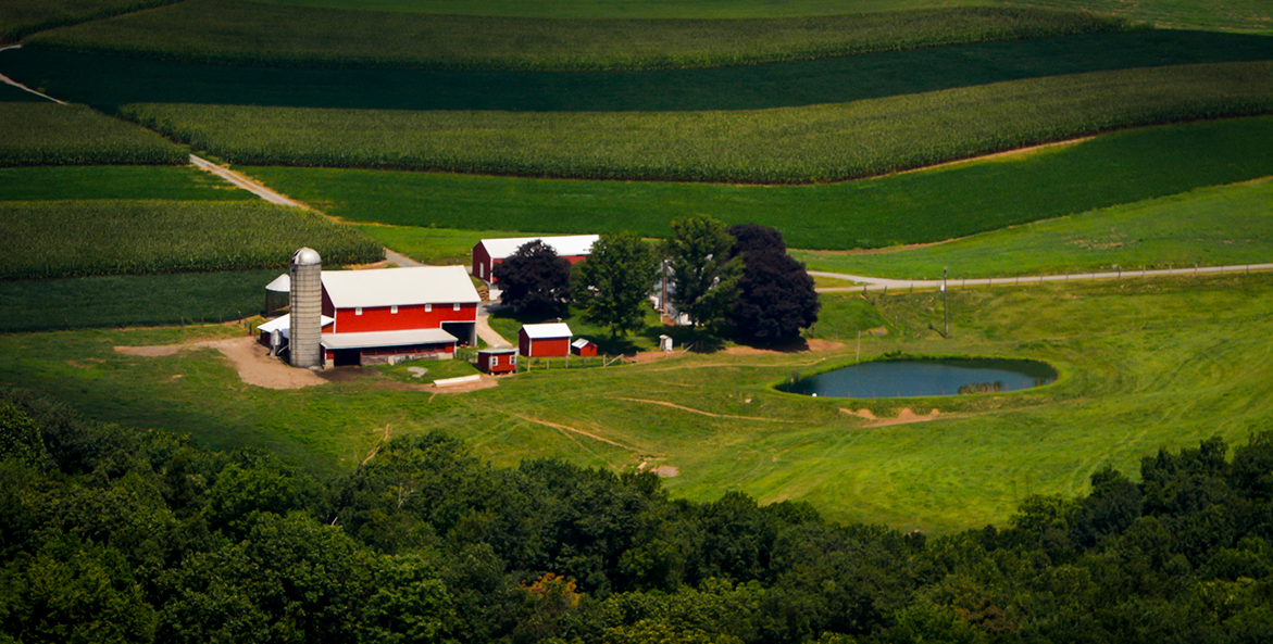 A red farm house sits amoung rolling agricultural hills in York County, Pennsylvania. 
