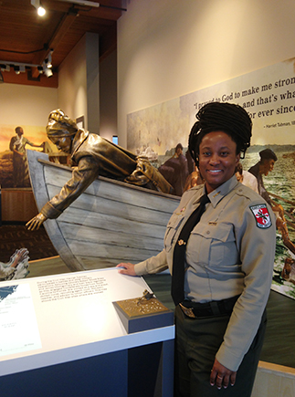 Woman park ranger stands next to museum exhibit