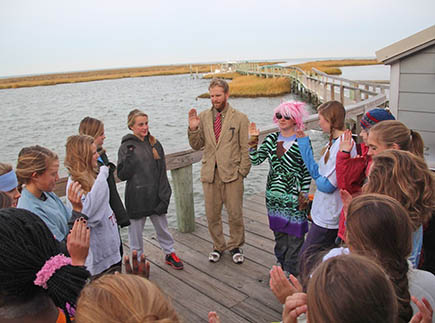 A man stands in a circle with students at Fox Island Education Center.