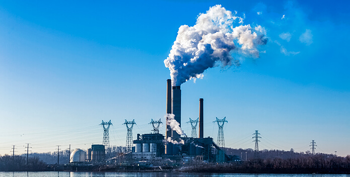 Photo of a power plant on the edge of a waterway.