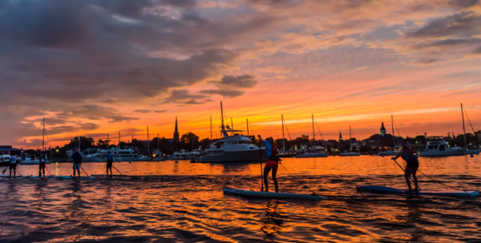 Image of a paddleboarders in the late summer sunset.