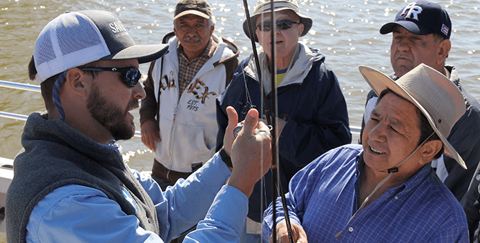 CBF Educator Rick Mittler rigs rods on a fishing trip with Richmond, Virginia Hispanic leaders.