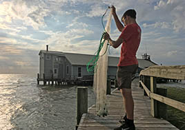 Boy with fishing net in front of Fox Island Lodge in the middle of the Chesapeake Bay.