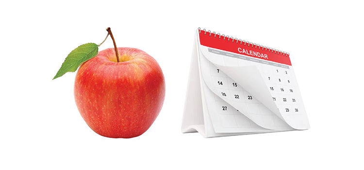 Red apple positioned next to a calendar.