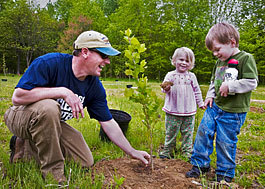 Father and children plant a tree at Holly Beach Farm.