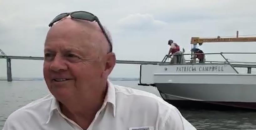 Man on a boat with the boat named Patricia Campbell in the background.