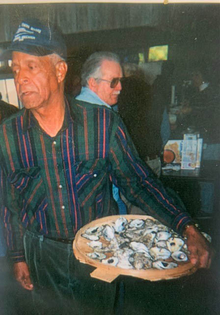 A man standing with a plate full of oysters.