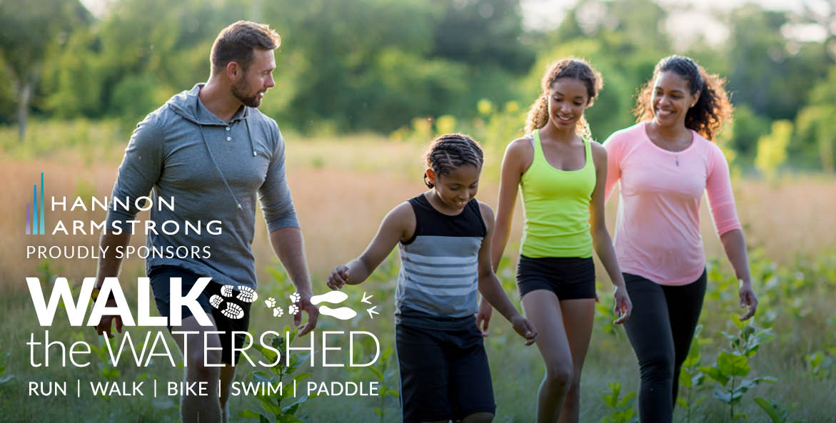 A multiracial family walks through a field.