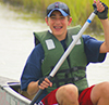 A smiling student canoeing during a CBF field experience. Photo by CBF Staff.
