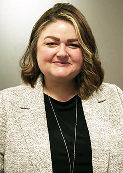 A white woman smiles at the camera face-on.