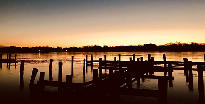 Photo of empty docks backlit by the sunrise.