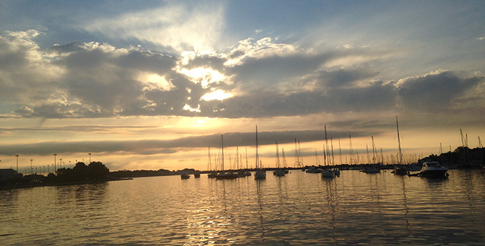 Sunset over the Bay with sailboats in a harbor. 