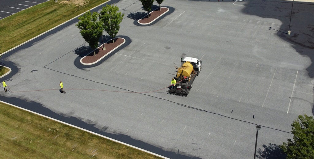 Sealant is applied to a parking lot