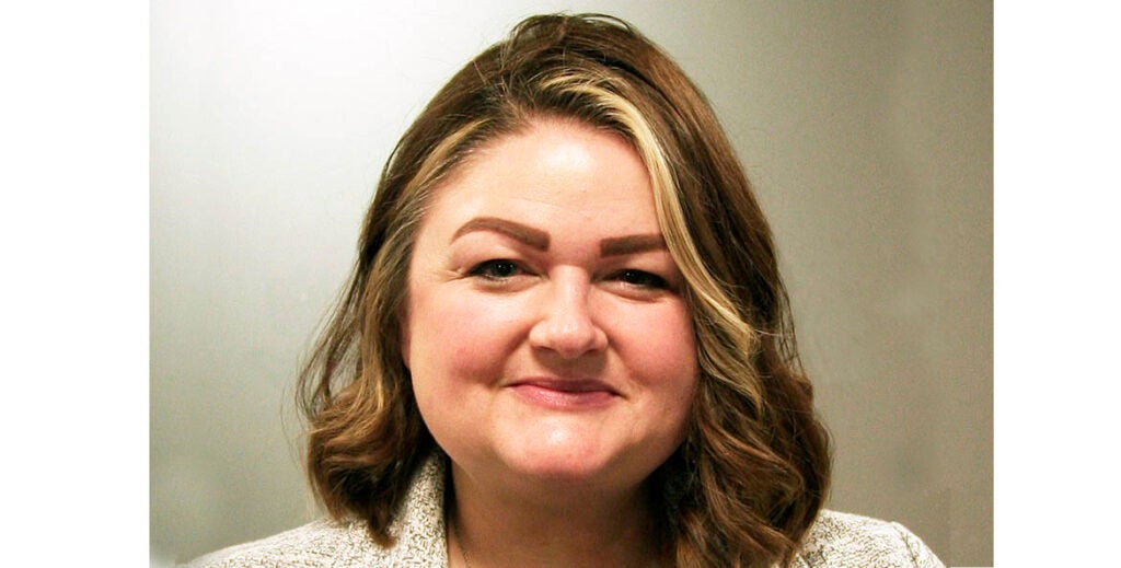 A head and shoulders portrait of Julia Krall, who smiles for the camera