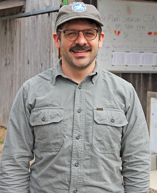 Thomas Arminio, in a gray CBF ball cap and gray work shirt, smiles at the camera.