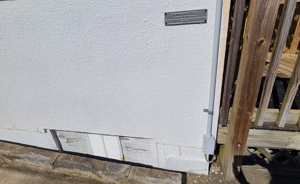 A plaque reading Hurricane Isabel High Water Mark 2003 sits high on a white wall.