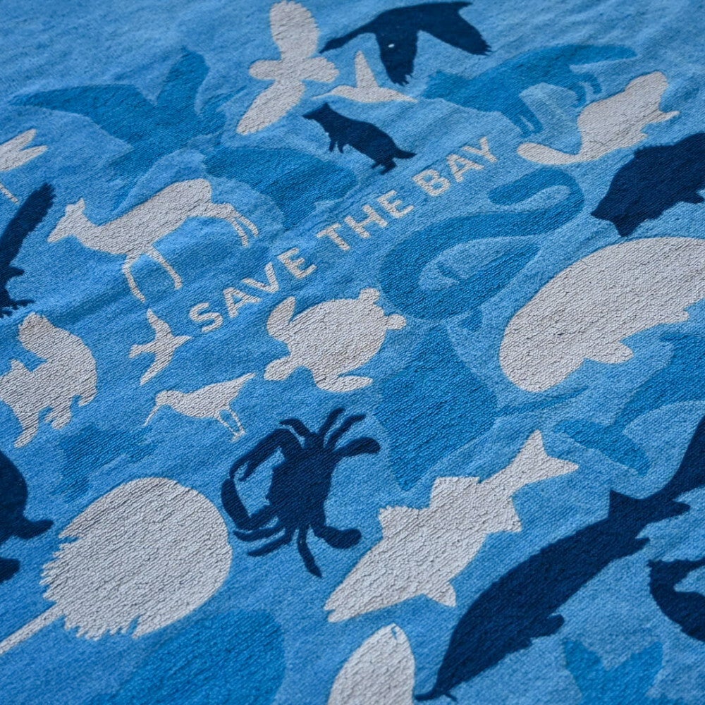 Close-up of a blue beach towel with the words Save the Bay and images of crabs, turtles, fish, and other animals.