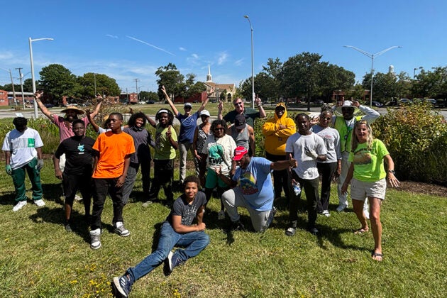 Group of volunteers posing with tools at a green infrastructure planting site.