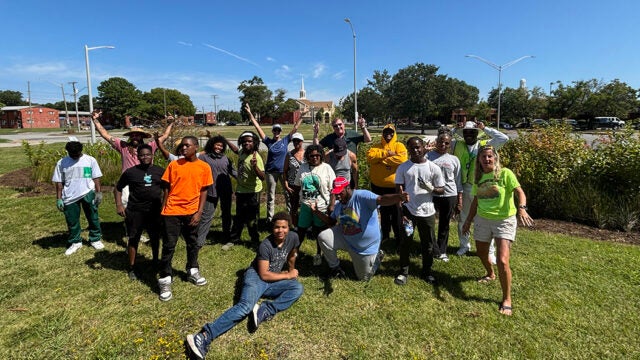 Group of volunteers posing with tools at a green infrastructure planting site.