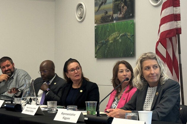 Panel discussion with five speakers at table.
