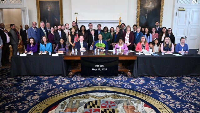 Officials and supporters gather for the signing of HB 506 in Maryland's State House on May 13, 2025.