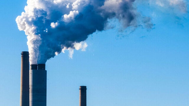 Steam billows from a power plant smokestack.