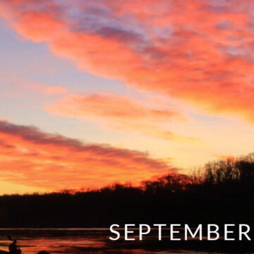 An orange sunset over a river.