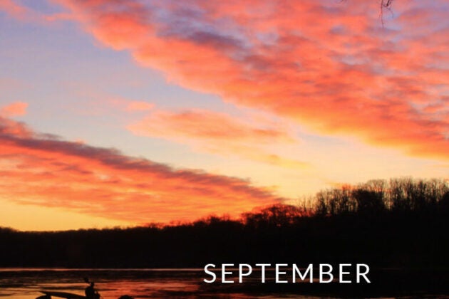 An orange sunset over a river.