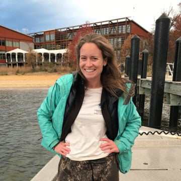 A woman standing on a boat in front of a dock on the Chesapeake Bay.